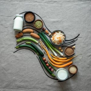 Orthomoleculair therapeut Groningen – top‑down compositie met gefermenteerde voeding, vezelrijke peulvruchten, groenten, noten en zaden op een linnen achtergrond; focus op gezonde darmen, spijsvertering verbeteren en energie herstellen.
