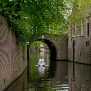 Een vrouw mediteert in lotushouding op een mat, drijvend op de serene Binnendieze in Den Bosch, omringd door historische gebouwen en rustgevende wateren.