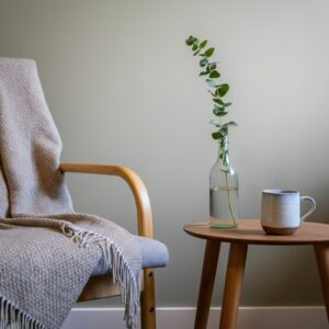 Reiki sessie Heemstede: rustige behandelkamer met houten bijzettafel, kruidenthee en groene tak, warme natuurlijke tinten voor ontspanning en herstel