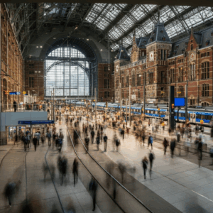 Drukte op station Amsterdam CS, met focus op het opbouwen van verwerkingscapaciteit na een agressie-incident.