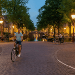 Een serene avondweergave van Utrecht's singels, met fietsers die langs het water rijden en de stad verlicht door warme lichten.